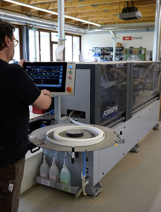 Schreiner bei der Arbeit an einem Massivholzmöbel